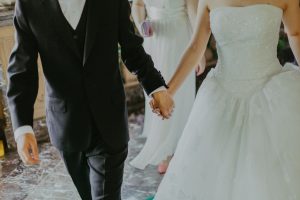 Mand og brud holder i hånd til bryllup